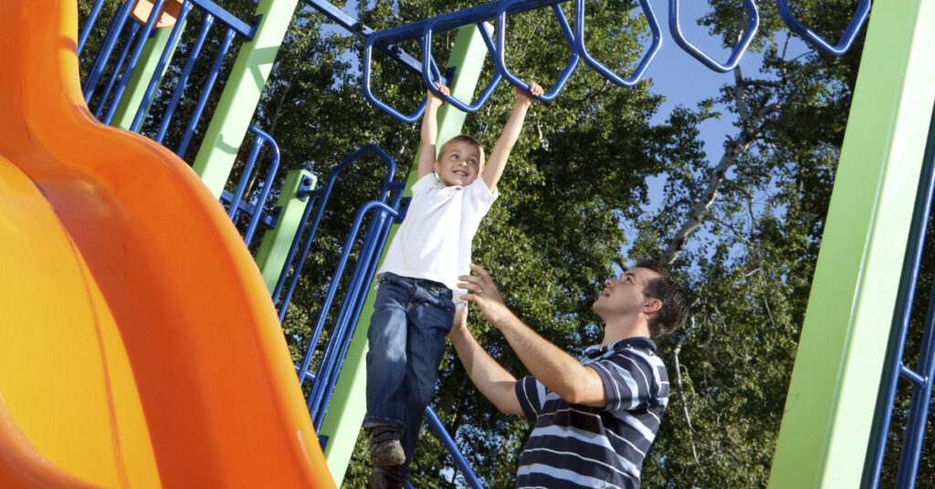 Child and Father playing in community park